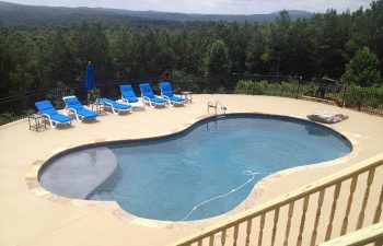 Lounge chairs on a deck of a backyard swimming pool installed by Premier Pool Enterprises