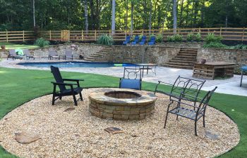 Garden chairs around a stone fire pit built by Premier Pool Enterprises