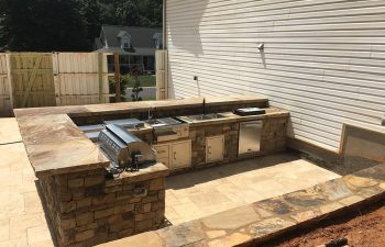 An outdoor stone kitchen built by Premier Pool Enterprises