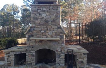 An outdoor stone fireplace built by Premier Pool Enterprises