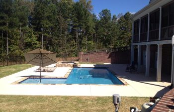 Backyard swimming pool with a a hot tub installed by Premier Pool Enterprises