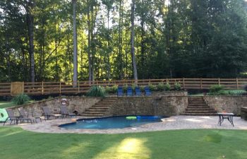 Backyard swimming pool with water features installed by Premier Pool Enterprises