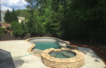 Backyard swimming pool with a hot tub installed by Premier Pool Enterprises