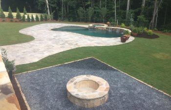 Backyard swimming pool with hot tub and water features installed by Premier Pool Enterprises