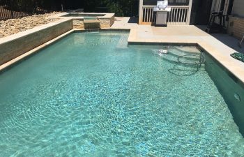 Backyard swimming pool with hot tub installed by Premier Pool Enterprises