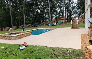 Premier Pool Enterprises workers while adding a hot tub to an outdoor swimming pool.