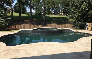 Backyard swimming pool with hot tub installed by Premier Pool Enterprises