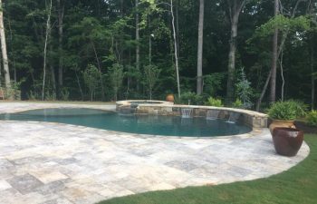 Backyard swimming pool with hot tub and water features installed by Premier Pool Enterprises.