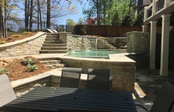 home outdoor living space with hardscaped pool and water features