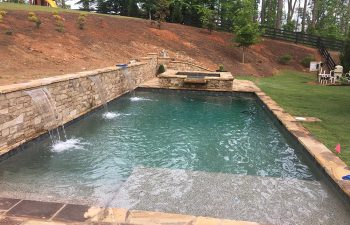 backyard swimming pool with hardscaped hot tub and water features