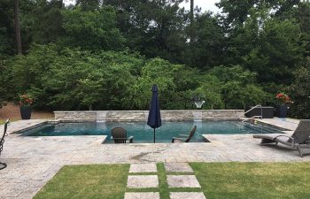 backyard swimming pool with water features and pool furniture