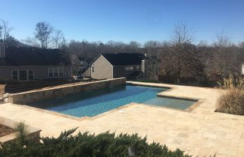 Backyard pool with water features built by Premier Pool Enterprises.