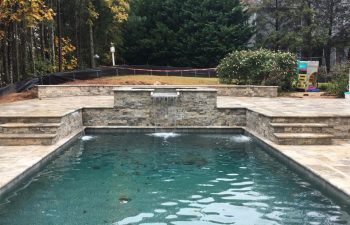 backyard swimming pool with hot tub and water features