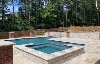 outdoor modern pool with hot tub and stone paver patio