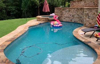 backyard swimming pool with hot tub and water features