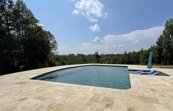 modern yard swimming pool with pool chairs and umbrella installed in water