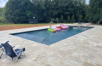 modern backyard pool with inflatable floating lounges