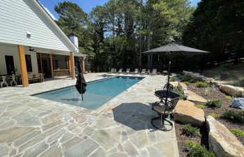 backyard flagstone patio with a modern swimming pool