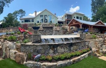 a residential house with a hardscaped pool with water features
