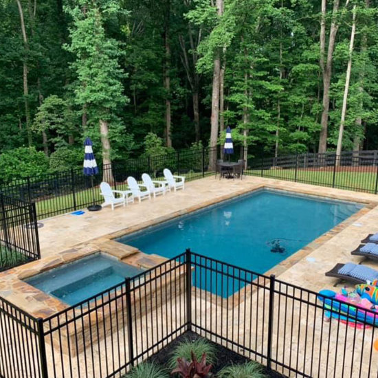 backyard swimming pool with hot tub and pool furniture on the flagstone deck