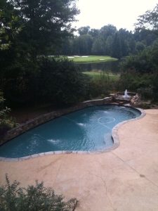 A backyard swimming pool remodeled by Premier Pool Construction, LLC