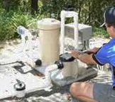 Premier Pool technician repairing a swimming pool filter.